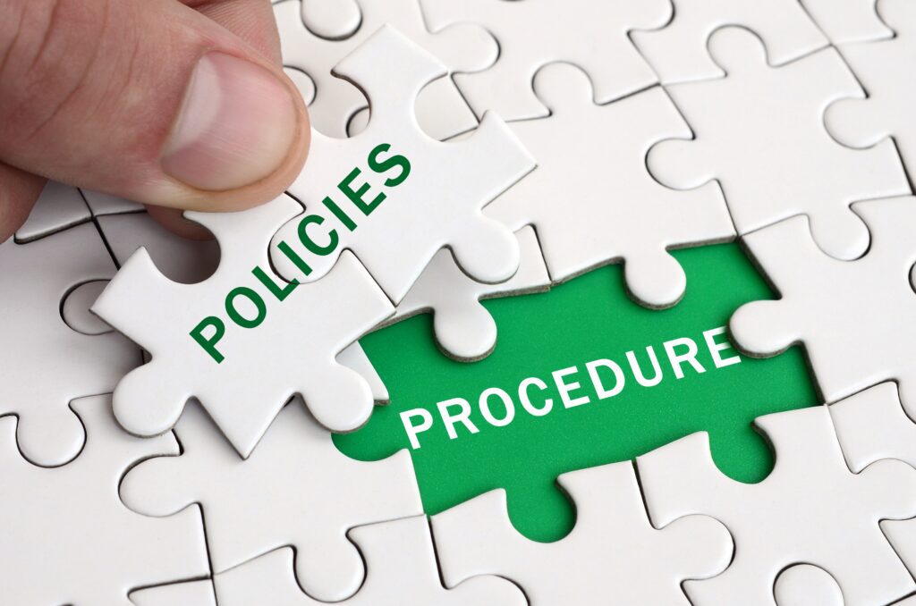 puzzle con tesserino "POLICIES" che si incastra su "PROCEDURE": metafora dell'integrazione tra polizze assicurative e procedure operative per una protezione aziendale efficace