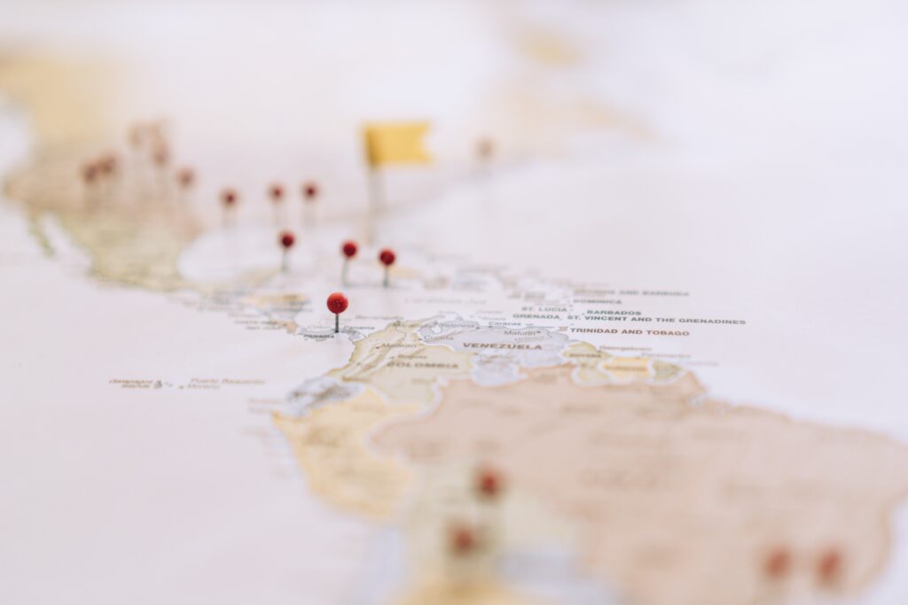 mappa geografica del Sud America e Caraibi con puntine rosse e bandierina gialla che simboleggia i rischi internazionali legati all'investimento del TFM in coperture assicurative