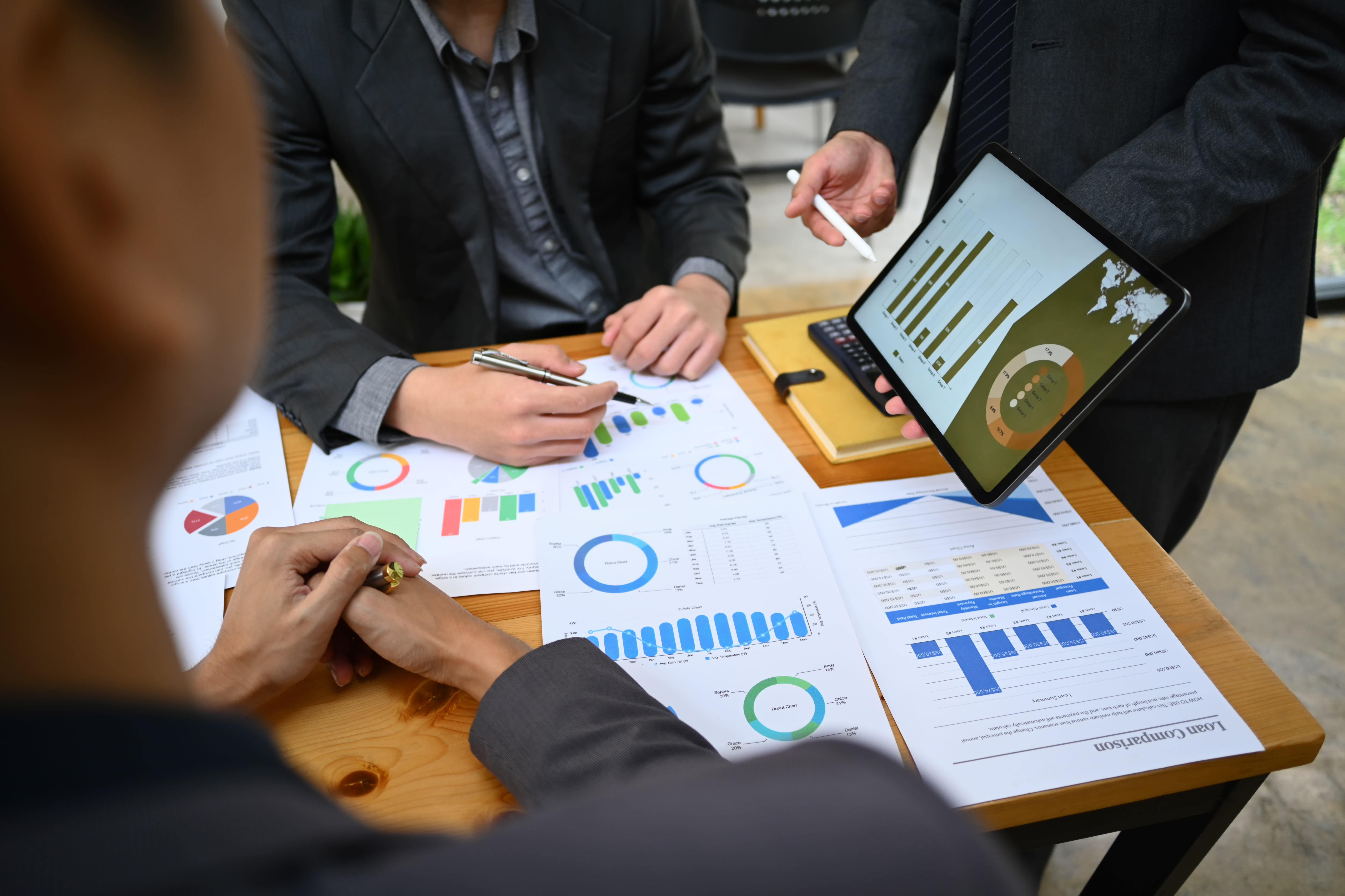 consulenza risk management: team di esperti riuniti intorno a un tavolo che analizza grafici, documenti e dati per definire i servizi di gestione dei rischi aziendali
